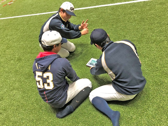 本学野球部がタブレットで動画を確認する様子