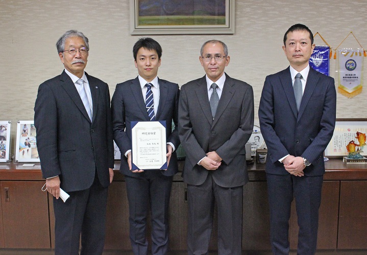 左から松下学長、加地さん、荻田教授、共同研究の和田智仁教授