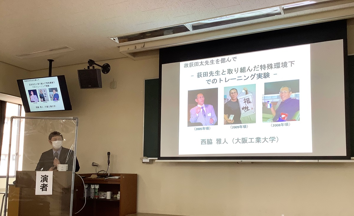 在りし日の荻田先生の写真をスライドに写しながら話す西脇先生