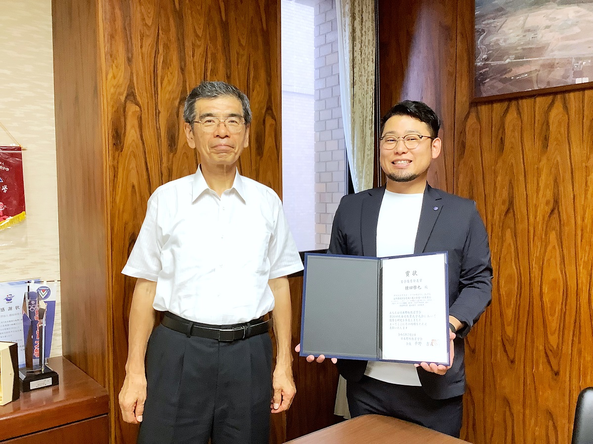 学長と、賞状を手にする棟田先生の写真